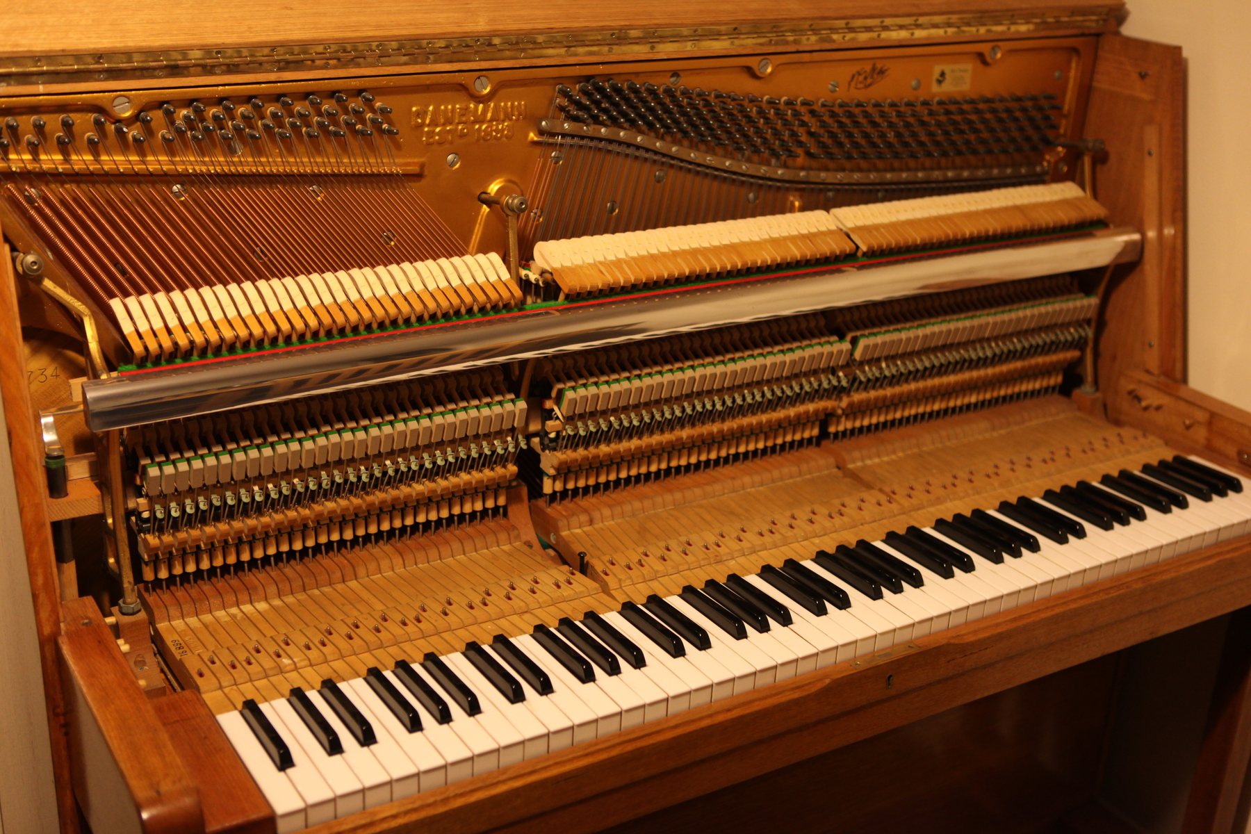 Piano droit ouvert montrant la mécanique et les cordes